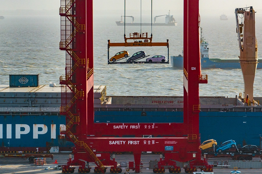 Three electric vehicles as viewed on a lift in a port.